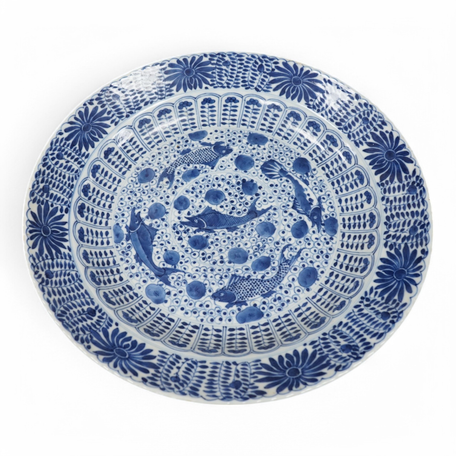 A Chinese blue and white 'fish' dish, Kangxi mark but c.1900, 33cm diameter. Condition - slight chipping to rim